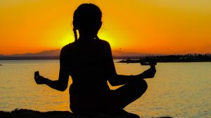 woman meditating sunset